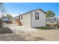 Charming single-story home with a well-manicured lawn, new concrete driveway, and appealing exterior paint at 8497 Madison Way, Denver, CO 80229