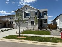 Beautiful two-story home featuring stone accents, manicured lawn, and attached two-car garage at 1131 Joseph Pl, Erie, CO 80026