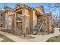 Condo exterior shows a brown multi-story building with stone accents and metal staircase at 10056 W Unser Dr # 204, Littleton, CO 80127