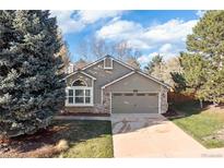 Charming home features a front lawn, attached garage and stone accents at 21593 Hill Gail Way, Parker, CO 80138