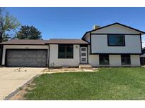 Charming two-story home with a well-maintained lawn and a convenient attached garage at 2513 S Crystal St, Aurora, CO 80014