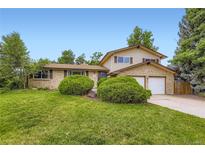 Charming two-story home with a well-maintained lawn, brick accents, and mature trees at 1497 S Oakland St, Aurora, CO 80012