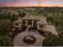 Stunning aerial view of a custom home with a circular driveway and beautiful landscaping at 6371 Diamond Ridge Pkwy, Castle Rock, CO 80108