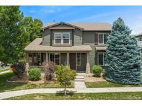 Charming two-story home with a covered front porch and well-manicured lawn at 10550 Sedalia St, Commerce City, CO 80022