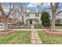 Charming two-story home with mature trees, black iron fence, and inviting walkway at 204 S Logan St, Denver, CO 80209