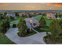 Stunning home with a circular driveway and meticulous landscaping, set against a beautiful sunset backdrop at 485 Sapphire Dr, Castle Rock, CO 80108