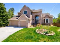 Charming two-story home featuring a manicured lawn, brick accents, and a spacious three-car garage at 9688 Chesapeake St, Highlands Ranch, CO 80126