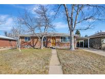 Charming single-story brick home featuring a welcoming walkway and a convenient carport for covered parking at 4040 S Inca St, Englewood, CO 80110