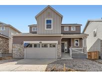 Charming two-story home with a stone-accented facade and attached two car garage at 24716 E Evans Dr, Aurora, CO 80018