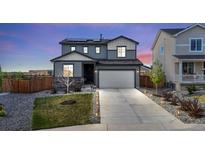 Charming two-story home features a manicured front yard, a two-car garage, and solar panels on the roof at 21 N Edge Cliff St, Castle Rock, CO 80104