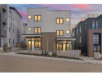 Contemporary townhome with a modern facade, clean lines, and a landscaped front yard under a colorful dusk sky at 1252 Yates St, Denver, CO 80204