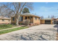 Charming brick home with a large front yard and a detached garage accessible via a long driveway at 2562 S Xavier St, Denver, CO 80219