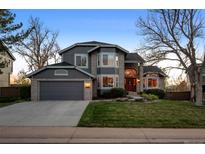 Beautiful two-story home with a well-manicured lawn, brick accents, and an attached two-car garage at 2042 Chesapeake Pl, Highlands Ranch, CO 80126