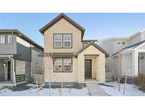 Tan two-story home with stone accents and a front walkway at 7312 Watercress Dr, Littleton, CO 80125