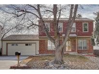 Two-story brick home with attached garage and landscaped yard at 1455 S Vaughn Cir, Aurora, CO 80012