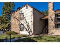 Charming condo with a mix of stone and siding, complemented by well-maintained landscaping and a clear blue sky at 7790 W 87Th Drive Dr # D, Arvada, CO 80005