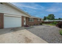 Charming single-story brick home featuring an attached garage and gravel front yard at 9320 W 48Th Ave, Wheat Ridge, CO 80033