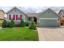 Charming home featuring a well-manicured lawn, red shutters, and beautiful landscaping at 2840 Canyon Crest Ln, Highlands Ranch, CO 80126
