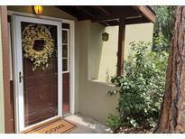 Inviting front door with glass panel, decorative wreath, and 'Welcome' mat at 23136 Kiowa Rd, Indian Hills, CO 80454