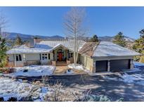 Mountain view home with a large yard and attached two-car garage at 334 Humphrey Dr, Evergreen, CO 80439
