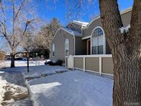 Tan exterior of home with snow on ground at 5866 W Asbury Pl, Lakewood, CO 80227