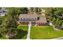 Charming two-story brick home with a well-manicured front yard and mature trees at 6279 E Princeton Ave, Cherry Hills Village, CO 80111