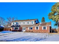 Brick ranch home with snow-covered lawn at 6279 E Princeton Ave, Cherry Hills Village, CO 80111