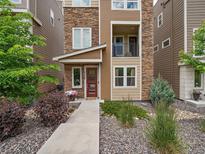 Charming townhouse exterior with stone accents, inviting entrance, and lovely landscaping at 2468 Channel Dr, Highlands Ranch, CO 80129