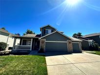 Charming home featuring a covered porch, large driveway, and a two-car garage for ample parking at 13472 Columbine Cir, Thornton, CO 80241