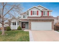 Charming two-story home featuring stone accents, gray siding, red shutters, and a well-maintained front yard at 23955 Glenmoor Way, Parker, CO 80138