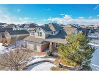 Two-story house with a three-car garage and snow-covered yard at 7949 S Blackstone Pkwy, Aurora, CO 80016