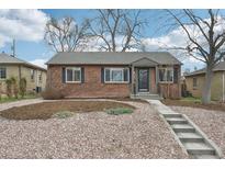 Charming brick home with landscaped front yard and concrete steps leading to the entrance at 1632 S Josephine St, Denver, CO 80210