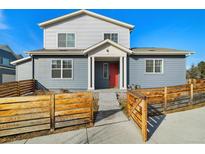 Charming two-story home featuring a red front door and a well-maintained fenced yard at 6111 W 28Th Ct, Wheat Ridge, CO 80214