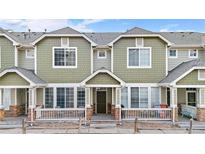 Green townhome exterior with front porch and landscaping at 15945 E Geddes Dr # 54, Aurora, CO 80016