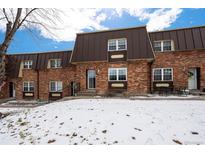 Charming brick townhome exterior with unique architectural details and snowy front yard at 5747 S Lowell Blvd, Littleton, CO 80123