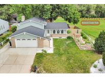 Charming home with a two-car garage, beautiful lawn, and an adjacent path, inviting outdoor adventures at 10869 W 65Th Way, Arvada, CO 80004