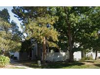 Charming townhouse with a white picket fence and mature trees providing shade and curb appeal at 1180 S Monaco Pkwy # 3, Denver, CO 80224