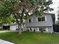 Charming two-story home features a well-manicured lawn, gray siding and white trim at 7132 Xavier Way, Westminster, CO 80030