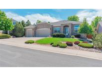 Charming single-story home with manicured lawn, brick exterior, and a two-car garage at 7211 Dolomite Ln, Castle Rock, CO 80108