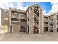 Multi-level exterior view showing the light brown siding and stairs leading to the units at 1273 S Gilbert St # A103, Castle Rock, CO 80104