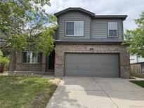 Charming two-story home featuring a gray exterior, brick accents, and a two-car garage at 4338 N Ceylon Ct, Denver, CO 80249