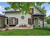 Charming two-story home with a quaint front porch and well-maintained landscaping at 6830 Lamar St, Arvada, CO 80003