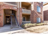 A brick apartment building with wooden balconies and exterior stairway at 1651 W Canal Cir # 613, Littleton, CO 80120