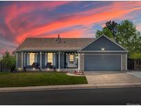 Charming single-Gathering home featuring a well-maintained lawn, covered porch, and two-car garage at 5342 S Halifax Cir, Centennial, CO 80015