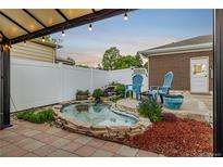 Outdoor living with a quaint brick-lined pond, water feature, and pergola-covered patio perfect for relaxing at 10478 Ogden St, Northglenn, CO 80233
