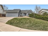 Charming single-Gathering home boasts a well-manicured lawn and a classic gray exterior at 5133 S Flanders Ln, Centennial, CO 80015