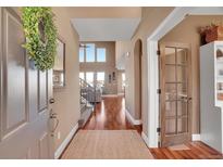Inviting foyer with hardwood floors, wreath decor, and a view into the living space at 8726 Gardenia Cir, Arvada, CO 80005