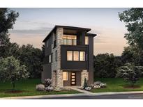 Modern three-story home featuring stone accents, a balcony, and a well-manicured lawn at 8628 Hotchkiss St, Littleton, CO 80125