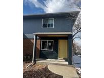 Charming blue two-story home featuring a covered porch and well-maintained front yard at 6029 S Sycamore St, Littleton, CO 80120