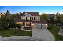 Two-story home with a large front yard, a well-manicured lawn, and a three-car garage at 3566 E Meadow Creek Pl, Highlands Ranch, CO 80126